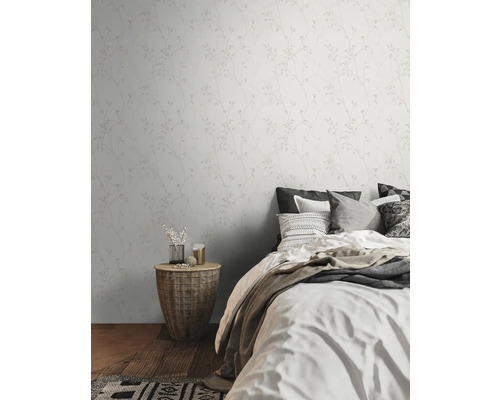 Schlafzimmer mit floral gemusterter Tapete, Bett und Korbtisch