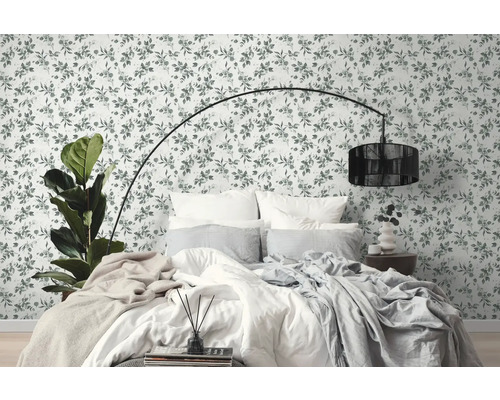 Schlafzimmer mit floraler Tapete, Bett und Stehlampe