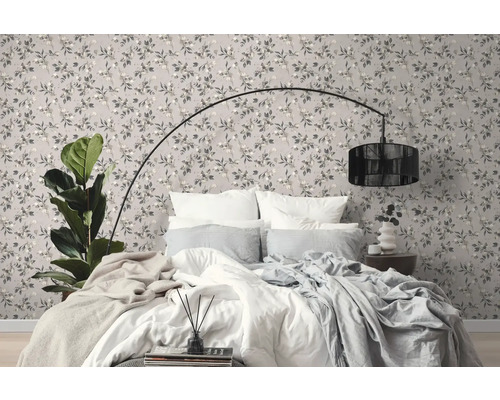 Schlafzimmer mit gemusterter Tapete, Bett und Stehlampe