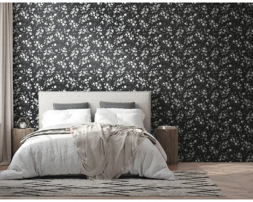 Schlafzimmer mit Bett vor dunkler Blättertapete