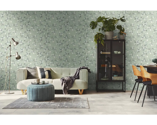 Heller Wohnraum mit einer Couch, einem Sessel und einer gemusterten Tapete.