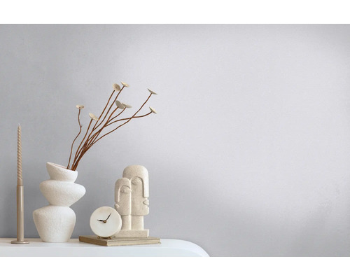 Dekorative Szene mit Vase, Trockenblumen, Kerze, Uhr und Skulptur auf einem Tisch.