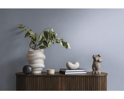 Dekorative Gegenstände und Pflanzen auf einem Sideboard aus Holz