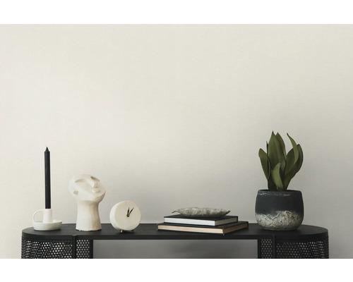 Dekorative Szene mit Kerze, Skulptur, Uhr, Büchern und Topfpflanze auf einer Konsole