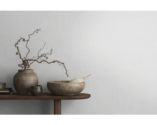 Dekorative Anordnung mit Schale, Vase und Ästen auf einem Holztisch