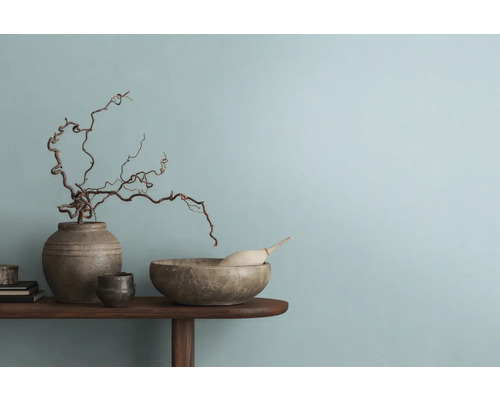 Dekoratives Arrangement mit Vase, Schale und Ästen auf einem Holztisch