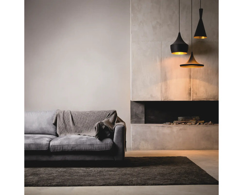 Wohnzimmer mit Sofa, Teppich, Kamin und Pendelleuchten