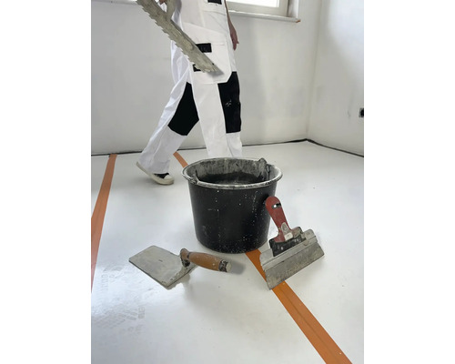 Raumrenovierung mit Spachtel, Glättkelle und Eimer Mörtel