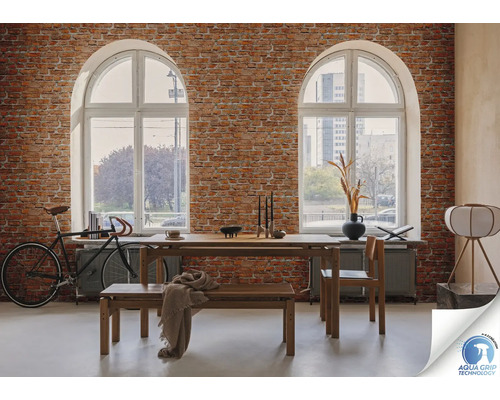 Wohnraum mit Backsteinmauer, Esstischgruppe, Fahrrad und zwei Bogenfenstern