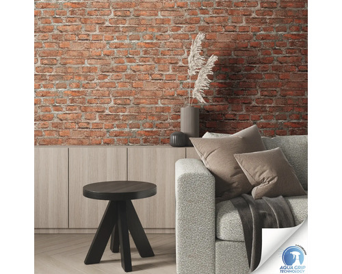 Wohnzimmer mit Backsteinwand, Sofa, Tisch und Kommode