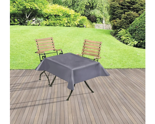 Gartenszene mit Tisch, Stühlen und grauer Tischdecke auf einer Terrasse