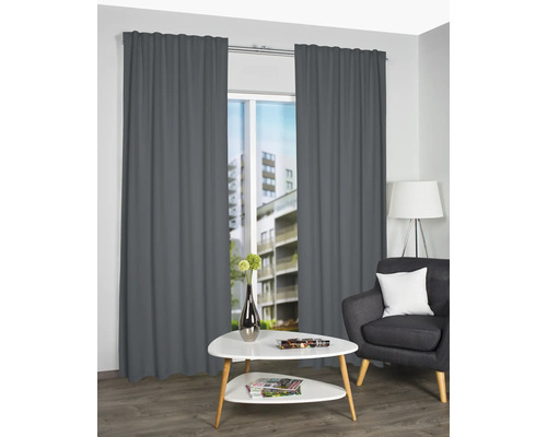 Wohnzimmer mit Vorhängen, Sessel und Tisch