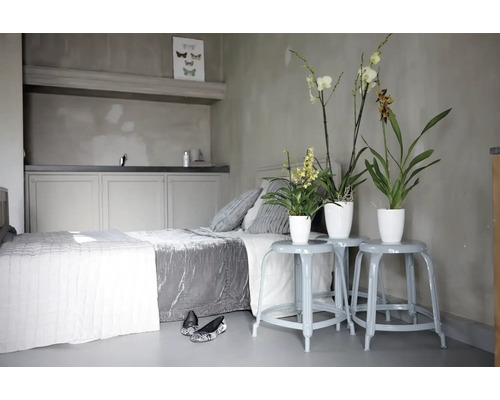 Schlafzimmer mit Bett, Nachttischen und Zimmerpflanzen