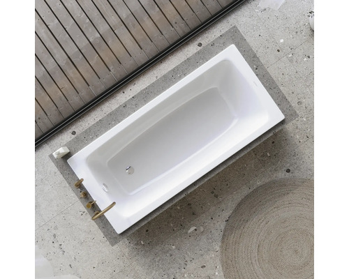 Rechteckige Badewanne in einem Badezimmer mit Holzwand und Fliesenboden