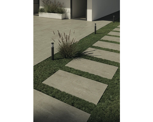 Außenaufnahme mit Steinplatten als Gehweg und Rasenflächen, kombiniert mit Bepflanzung und Außenleuchten.