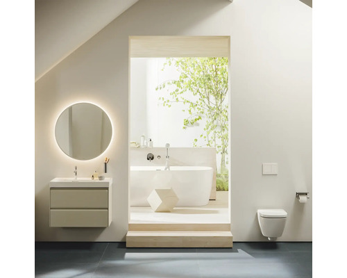 Badezimmer mit Waschtisch, beleuchtetem Spiegel, Badewanne und Wandtoilette