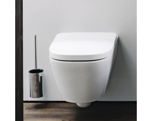 Wandhängendes WC mit Toilettenbürstengarnitur im Badezimmer.