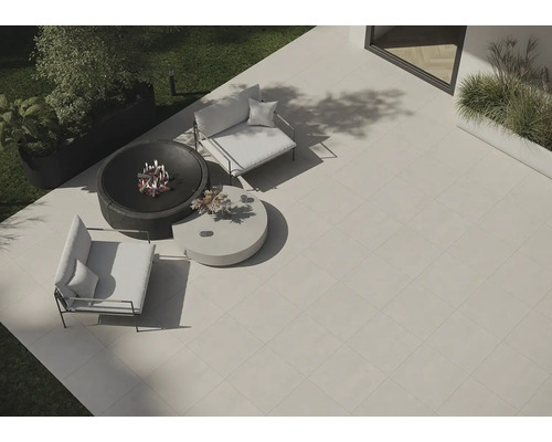 Gartenszene mit Terrassenplatten, Feuerschale und Sitzmöbeln für den Außenbereich.