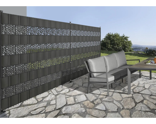 Gartenszene mit Sichtschutzzaun aus Kunststoff mit dekorativen Mustern, Gartenmöbeln und Steinboden