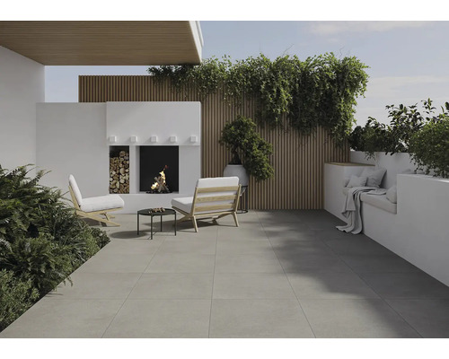 Terrasse mit Steinboden, Sitzgelegenheiten, Kamin und Pflanzen für eine gemütliche Atmosphäre im Freien