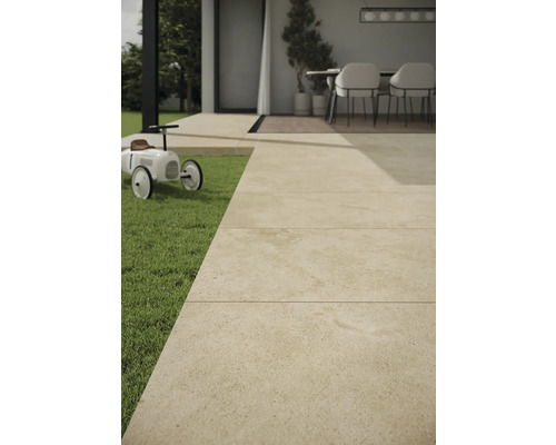 Außenbereich mit Steinfliesen, Rasenfläche und Spielzeugauto