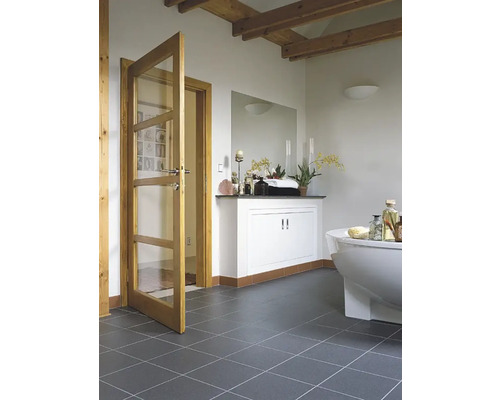 Badezimmer mit Badewanne, Waschtisch und Holztür mit Glaseinsatz