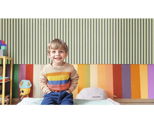 Helles Kinderzimmer mit gestreifter Tapete und lächelndem Kind