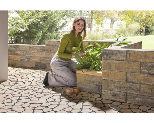 Frau arbeitet im Garten mit Pflanzsteinen und Bodenplatten