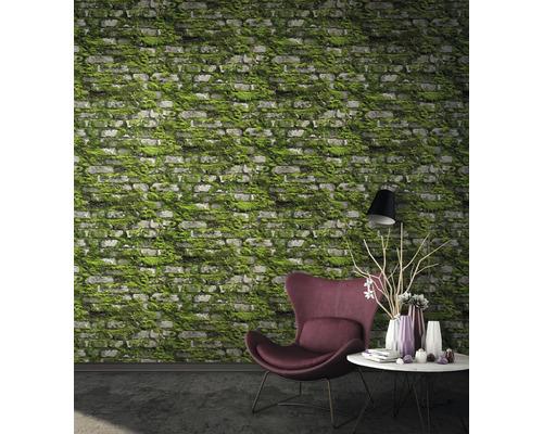 Wohnzimmer mit Ziegelwandtapete mit Moosbewuchs, Sessel und Tisch mit Dekoration