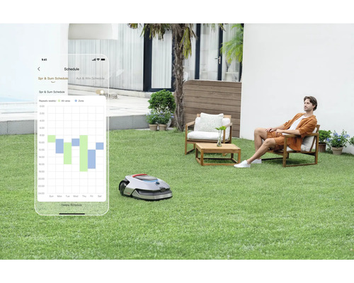 Rasenmähroboter mit App-Steuerung im Garten, während eine Person entspannt