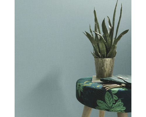 Tapete im Wohnraum mit Pflanze und Hocker.