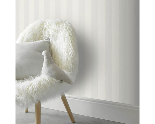 Raumansicht mit gestreifter Tapete und Stuhl mit Kissen