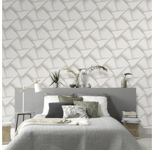 Schlafzimmer mit Bett vor einer Wand mit dreidimensionaler geometrischer Tapete