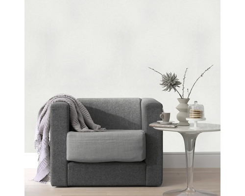 Sessel mit Überwurfdecke und Beistelltisch mit Dekoration