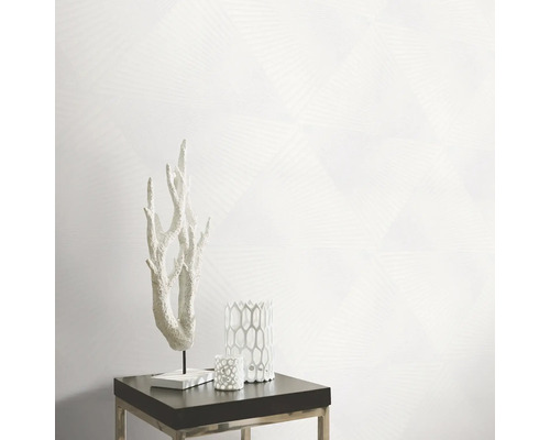 Dekorative Szene mit Korallenornament, Kerzenhaltern und geometrischer Tapete auf einem Beistelltisch.