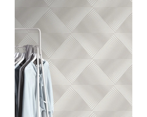 Dreieckige, weiße Wandfliesen mit abstraktem Muster und Kleiderständer