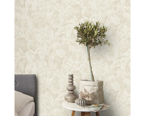 Ein Schlafzimmer mit einer Wand, die mit einer Tapete mit Blätterdruck versehen ist.