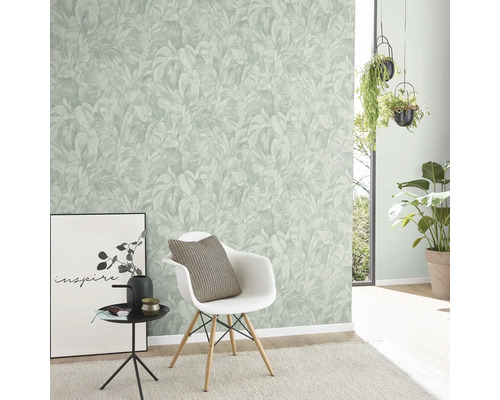 Wohnraum mit einer Wand mit einer Tapete mit Pflanzenmuster, einem Stuhl und dekorativen Elementen.