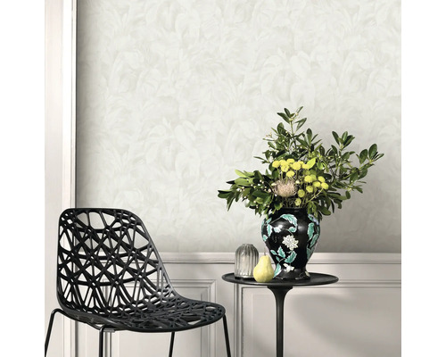 Wandgestaltung mit floralem Tapetenmuster, kombiniert mit einem schwarzen Stuhl und einem Beistelltisch mit Blumenvase