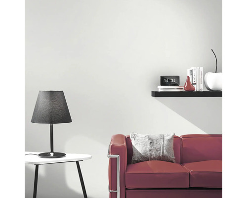 Wohnzimmer mit Sofa, Tischlampe und Wandregal