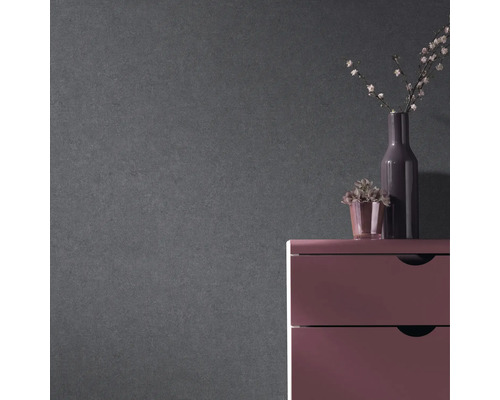 Dekorativer grauer Wandhintergrund mit Kommode, Vase und Pflanze