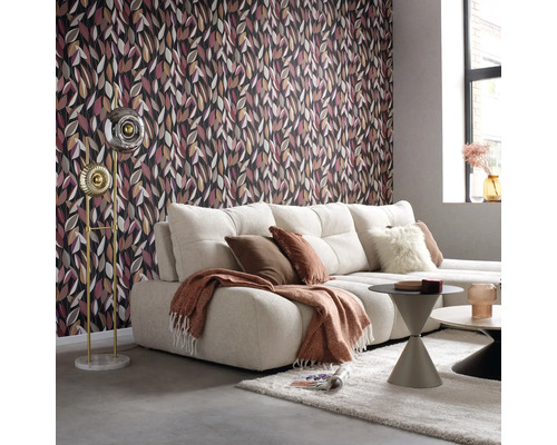 Wohnzimmer mit gemusterter Tapete, Sofa, Stehlampe und Couchtischen.