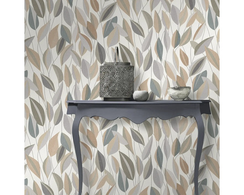 Dekorative Tapete mit Blattmuster und Konsole mit Deko-Objekten