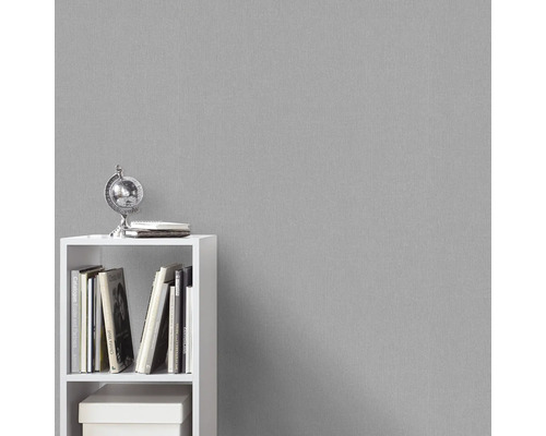 Graue Strukturtapete im Hintergrund mit weißem Regal und Dekoration