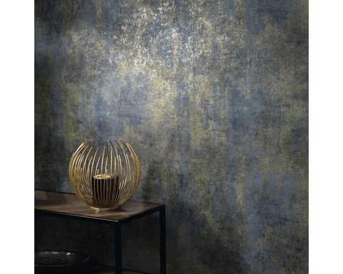 Nahaufnahme einer strukturierten Tapete mit einem abstrakten Muster in gedeckten Farben und einem goldenen Kerzenhalter