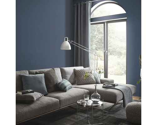 Wohnzimmer mit grauer Couch, Kissen, Lampe und Fenster