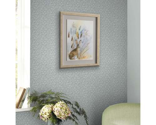 Dekorativer Raum mit gemusterter Tapete und einem gerahmten Hasenbild an der Wand