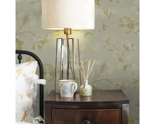 Nachttisch mit Lampe, Tasse und Duftölflakon in einem hellen Schlafzimmer