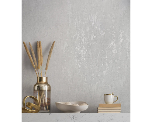 Dekorative Wand mit floralem Muster, Vase mit Pflanzen, Schale mit Deko-Elementen und Tasse auf Büchern