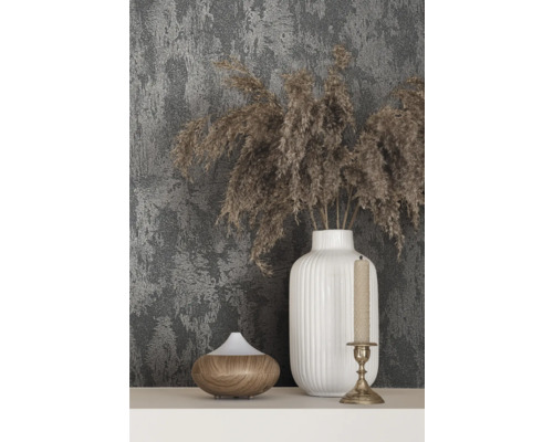 Dekoration mit Vase, Duftlampe und Kerzenständer vor einer gemusterten Wand